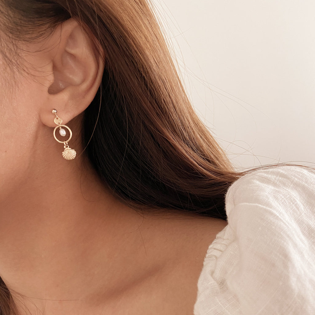 gold disc pearl drop seashell stud earrings on female ear
