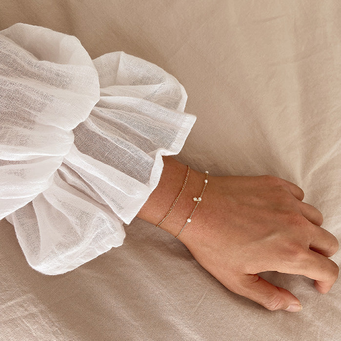 Guiding Light Pearl Bracelet pearls on gold chain on female hand
