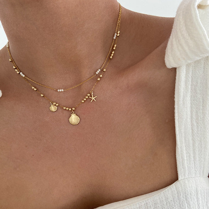 Gold necklace with seashell on female boho girl 